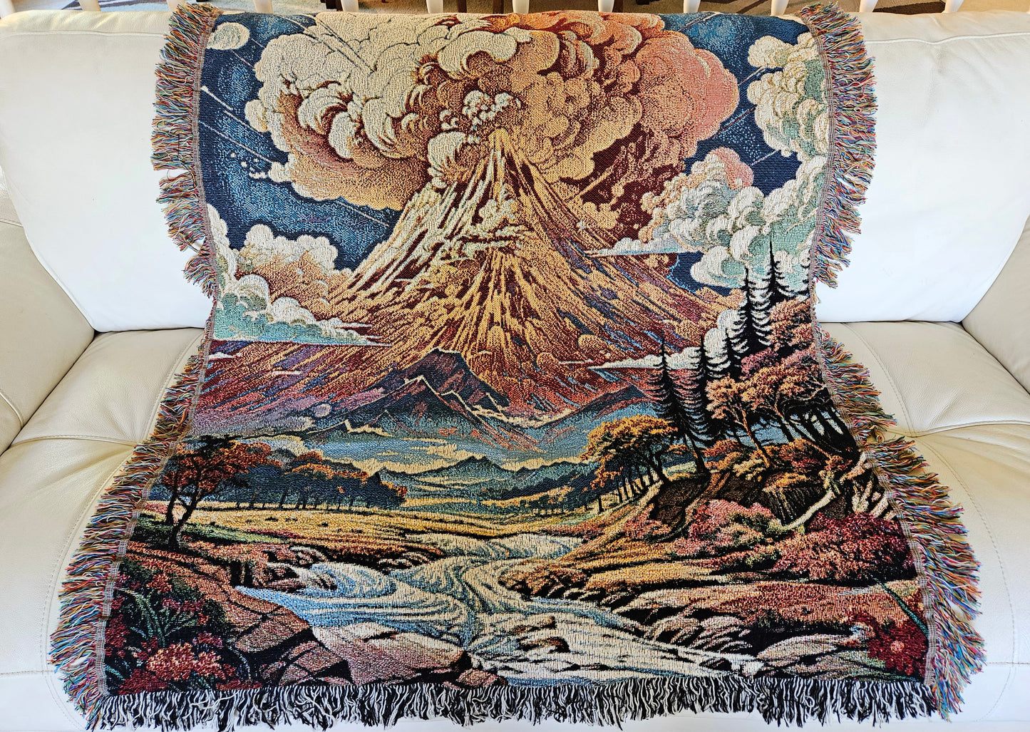 Summit Eruption Woven Blanket featuring a vibrant tapestry of a volcano, crafted from 100% cotton, perfect as a decorative throw or wall art.